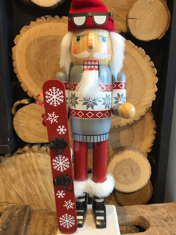 Nutcracker dressed in festive Christmas outfit holding his snowboard